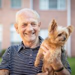 Man and dog GMI Stock - Point Pleasant Elderly man holding yorkshire terrier dog and smiling