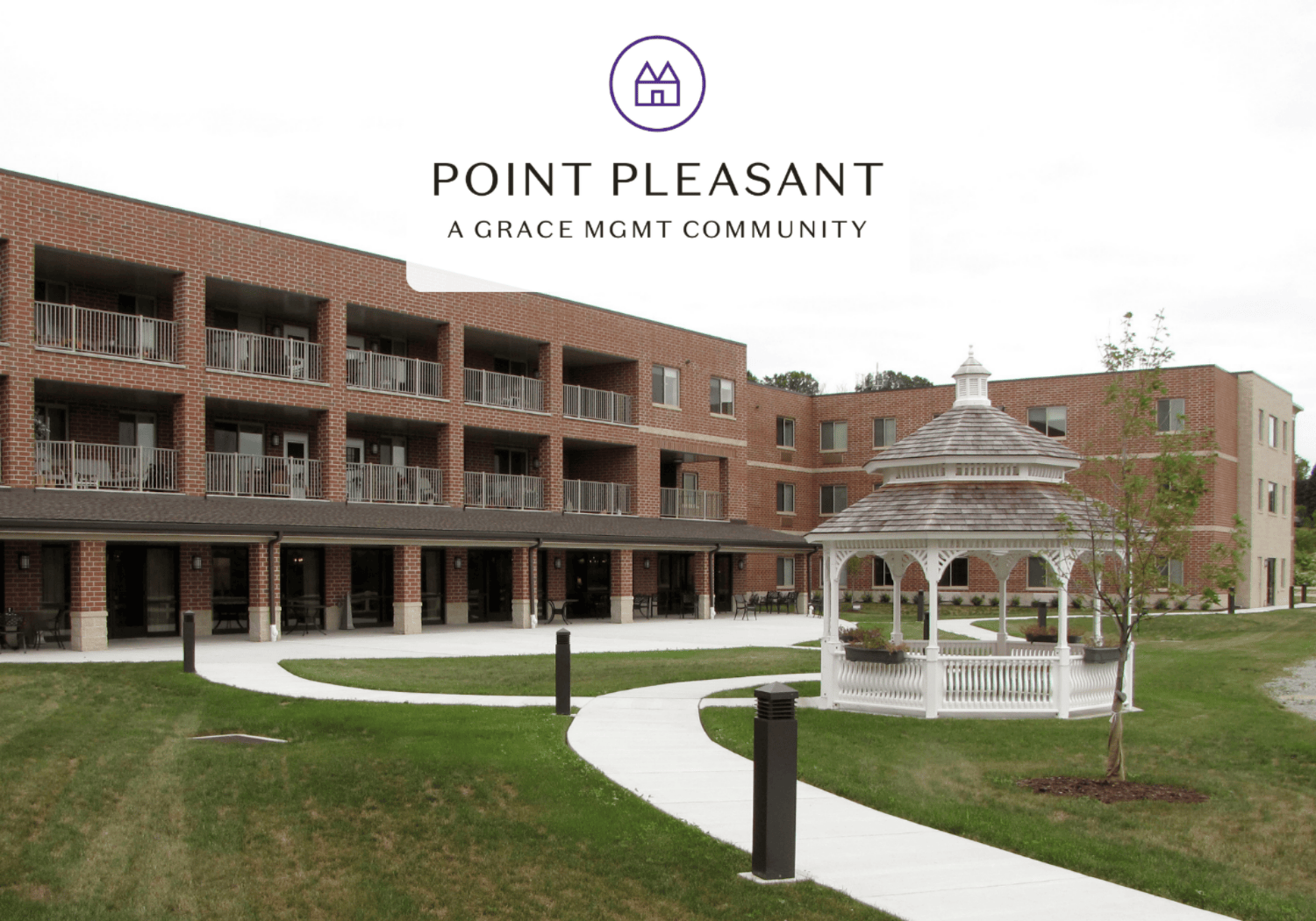 Brick apartment building with balconies and a white gazebo on a green lawn; Point Pleasant branding at the top.